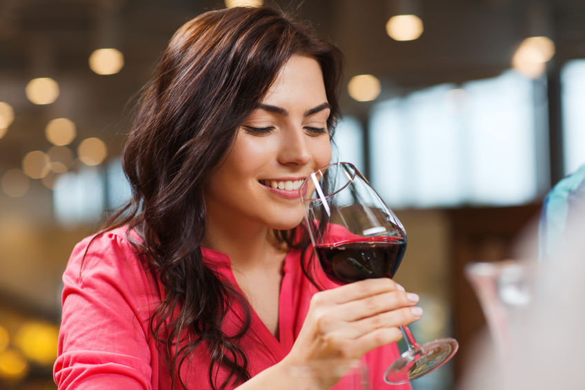 smiling woman drinking red wine at restaurant smiling woman drinking red wine at restaurant